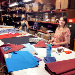 Elf Lindsey and Elf Nicole work on their aprons a safe distance from each other.