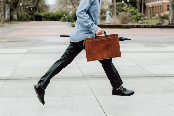 Business-formal dressed man leaping in barefoot Oxford shoes.