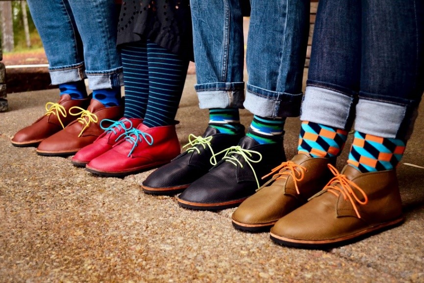 Four people in a row wearing Chukkas with colorful laces and the best colorful socks for wide feet